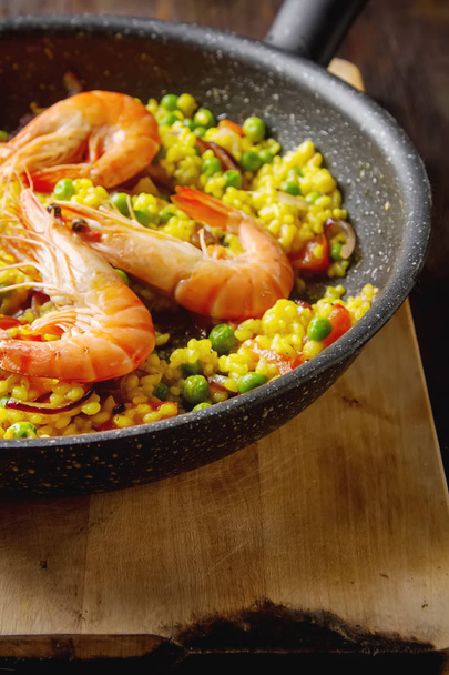 Spanish paella with seafood in a frying pan. Delicious lunch on  - Foto, Bild