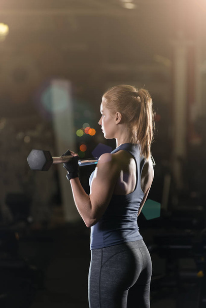 Young woman lifting the dumbbells - 写真・画像