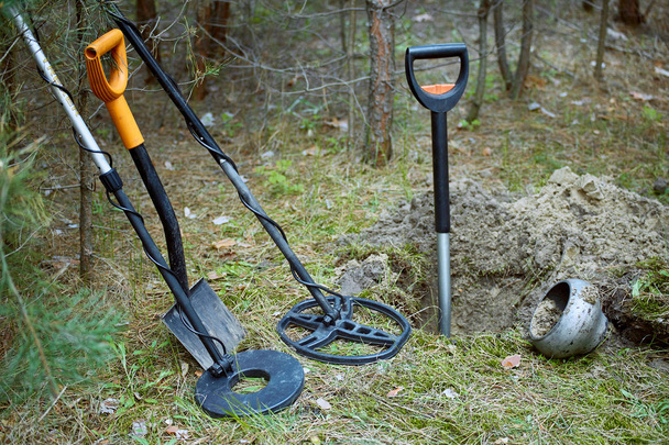 Search for treasure using a metal detector and shovel. - 写真・画像