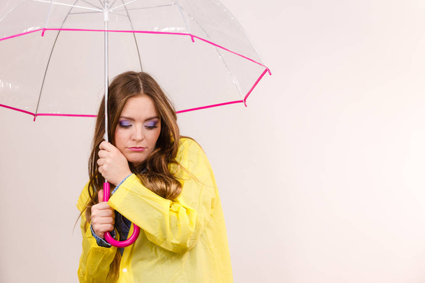 Woman under umbrella looking sad unhappy - 写真・画像
