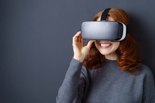 Усміхнена жінка насолоджується гарнітурою VR
 - Фото, зображення
