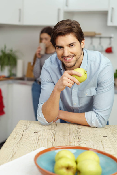 Handsome young man eating a healthy apple - Foto, Bild
