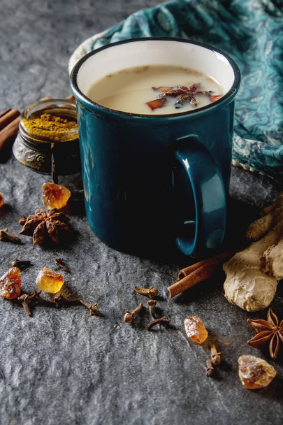Traditional Indian masala tea in ceramic cup with spices to milk - Foto, afbeelding