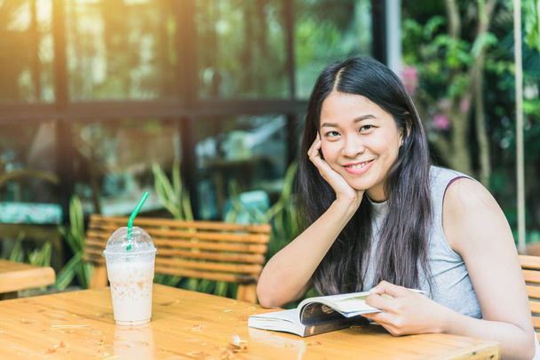 Zevk kez kitap okumak, kahve dükkanı vintage renk tonu kitapta Asyalı kadınlar Taylandlı teen gülümsemeyle ile rahatla - Fotoğraf, Görsel