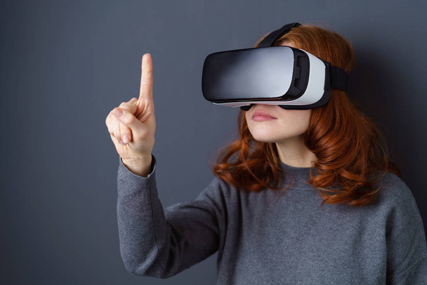 Young woman wearing VR glasses and pointing - Photo, image