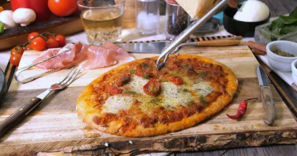 Grating parmesan cheese over an Italian pizza - Footage, Video