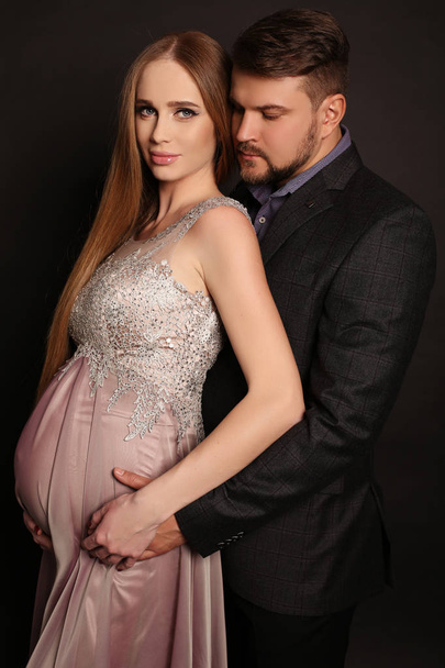 όμορφος άντρας που ποζάρει με πανέμορφο έγκυο γυναίκα - Φωτογραφία, εικόνα