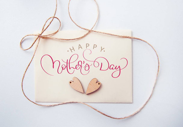 Holidays card with wooden heart and text Happy mothers day. Calligraphy lettering hand draw - Fotoğraf, Görsel