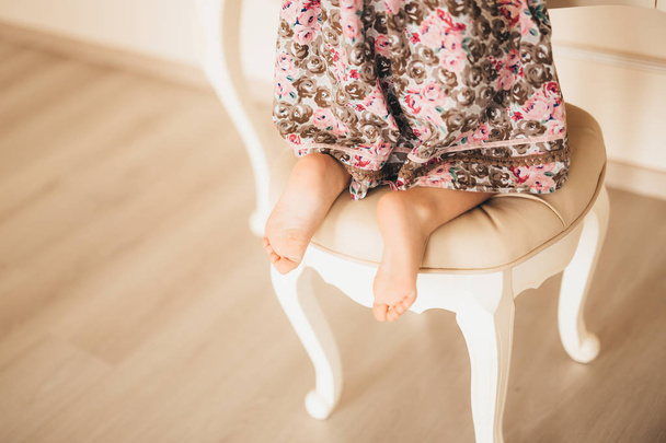 Nogi dziecka, mała dziewczynka w krześle przed mirr - Zdjęcie, obraz