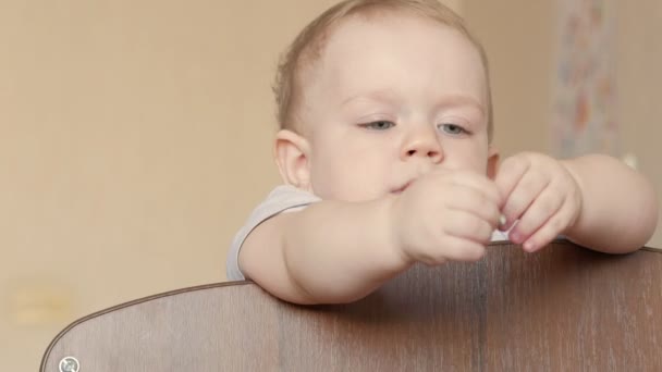 Bonito bebê loiro mostra jogando em um berço de bebê com um parafuso. Ele sorri e a torce em seus braços
 - Filmagem, Vídeo