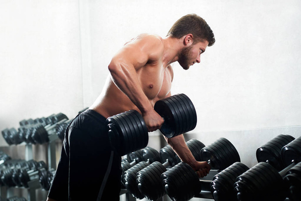 Handsome young athlete working out at the gym - Foto, Imagem