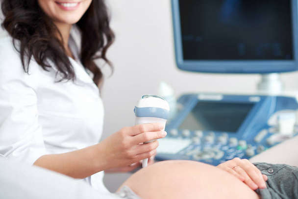 Doctor performing ultrasound scanning for her pregnant patient - Foto, Imagen