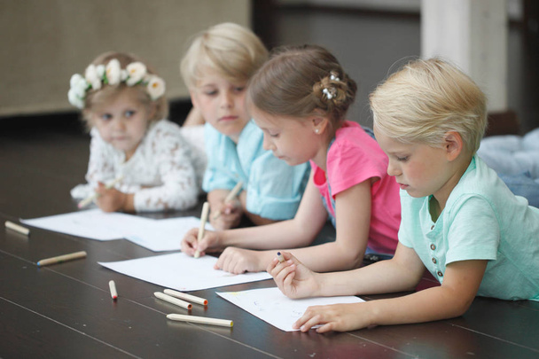 Group of cute children drawing with colorful pencils on floor - Фото, изображение