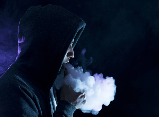 man vape an electronic cigarette with lots of smoke.  - Фото, зображення