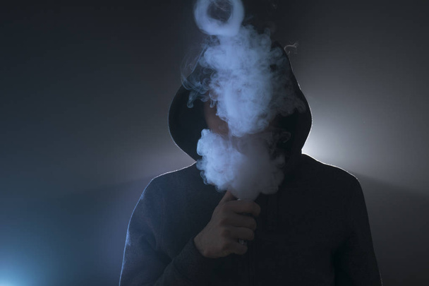 man vape an electronic cigarette with lots of smoke.  - Valokuva, kuva