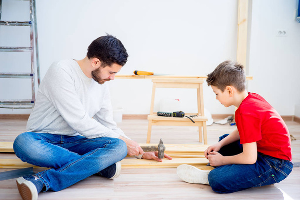 Father and son hammering nails - Foto, afbeelding