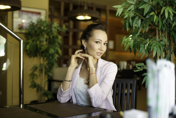 Nuori kaunis nainen istuu kannettava net-kirja kahvilassa sisustus, viehättävä unenomainen nainen käyttää matkapuhelin ja kannettava tietokone levon aikana kahvilassa
 - Valokuva, kuva