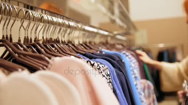 Mujer en una tienda de ropa eligió un vestido - concepto de compras
 - Imágenes, Vídeo