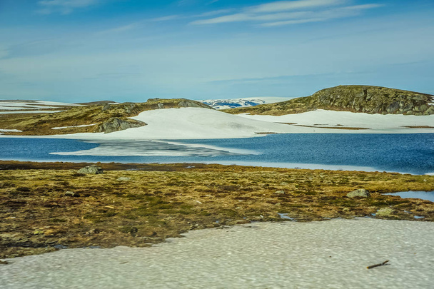 Hermoso paisaje y paisaje de Noruega, las colinas y la montaña cubierta parcialmente con nieve blanca y lago azul
  - Foto, Imagen
