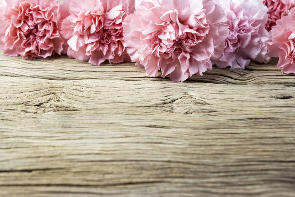 Ροζ γαρύφαλλο λουλούδια σε παλιό ξύλο  - Φωτογραφία, εικόνα