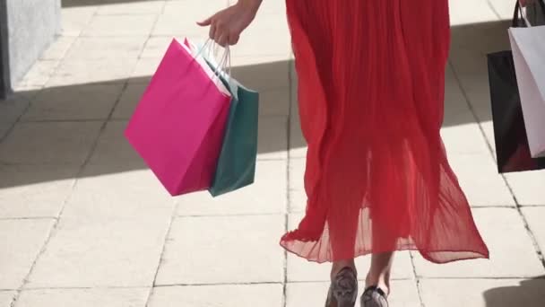 sexy legs of a beautiful girl that goes with shopping bags. slow motion - Filmmaterial, Video