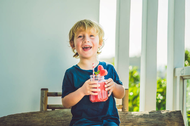  boy is holding Healthy watermelon smoothie - Foto, Imagen