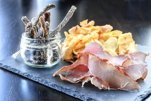 Beef pastrami sliced and potato chips, a snack to beer - Foto, imagen