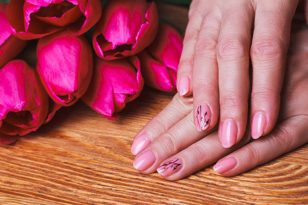 rosa Nagelkunst mit Blumen auf Holz Hintergrund - Foto, Bild