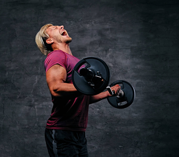 Krzyczący człowiek robi treningu bicepsów - Zdjęcie, obraz