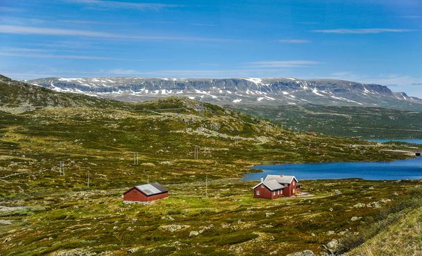 Красивий ландшафт і пейзажі з Норвегії, пагорби і гори покриті частково білим снігом і синє озеро  - Фото, зображення