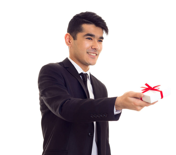 Νεαρός άνδρας στο κοστούμι κρατώντας ένα δώρο - Φωτογραφία, εικόνα