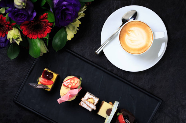 カフェラテのアートと花の花束とコーヒー カップ。事業のコンセプト - 写真・画像