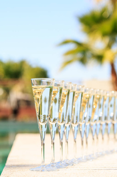 Nombreux verres de champagne ou de prosecco près de la piscine de villégiature dans un luxu
 - Photo, image