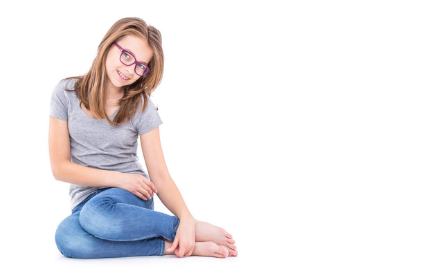 Young Pre-Teen girl in blue jeans and grey t-shirt isolated on white - Foto, afbeelding