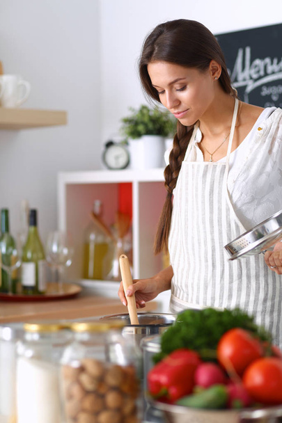 Cooking woman in kitchen with wooden spoon - Photo, image