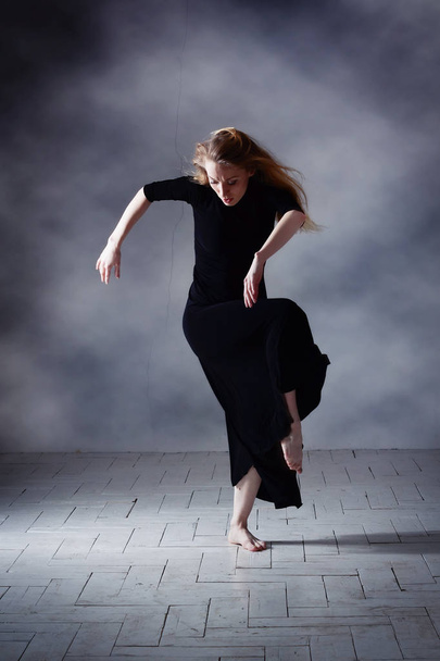 Modern ballet dancer posing on dark background - Photo, Image