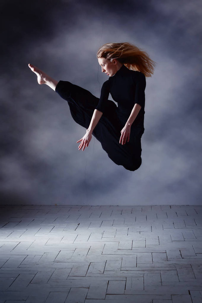 Сучасний балетмейстер позує на темному тлі
 - Фото, зображення