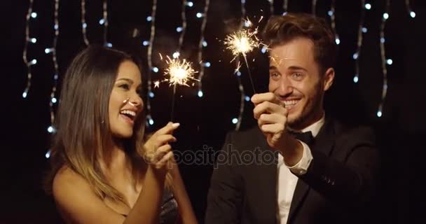 Young couple celebrating new year with sparklers - Кадры, видео