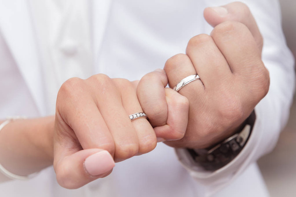 結婚指輪を入れて新郎新婦の手を閉じる - 写真・画像