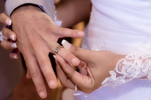 Close up hands of bride and groom putting on a wedding rings - Foto, imagen