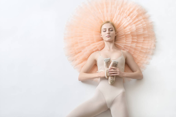 Blonde ballerina lies in studio - Фото, зображення