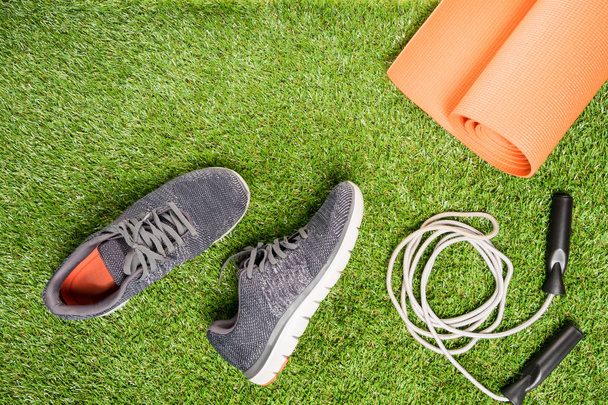 running shoes and skipping rope for training , on a grass background - Φωτογραφία, εικόνα