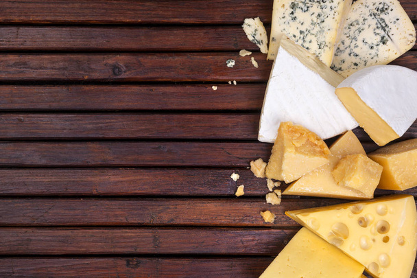 Various cheeses on wooden table with empty space. - Photo, Image