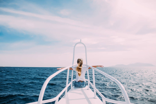 junge Frau vor Nase einer weißen Jacht mit erhobenen Händen genießen Wind und Meer. Sommerberuf - Foto, Bild