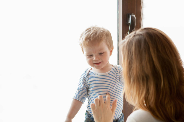 Матір з її усміхнений хлопчика, дивлячись у вікно - Фото, зображення