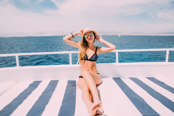 Привлекательная девушка отдыхает на яхте в летний день
 - Фото, изображение