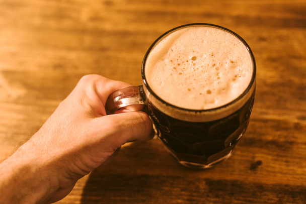 Man drinking dark beer in british dimpled glass pint mug - Photo, image