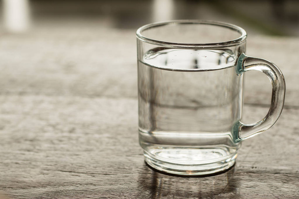 Склянка води на дерев'яній підлозі в кав'ярні з морем
 - Фото, зображення