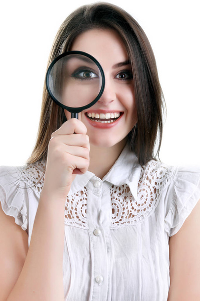 Beautiful girl portrait looking through magnifier. Isolated - Photo, Image