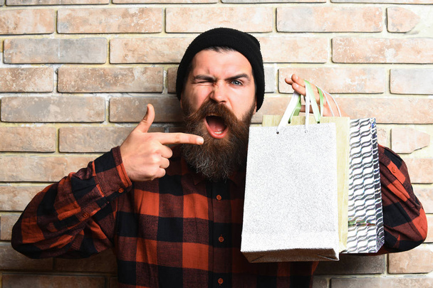 Bearded brutal caucasian hipster with moustache holding shopping packages - Photo, image